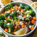 A vibrant bowl of Chicken Salad Chick Broccoli Salad featuring fresh broccoli florets, shredded cheese, crispy bacon bits, sunflower seeds, and a creamy dressing, perfect for recreating the Chicken Salad Chick Broccoli Salad recipe at home